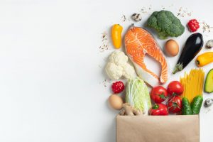 Supermarket. Paper bag full of healthy food. Supermarket. Paper bag full of healthy food on a white background. Top view. Flat lay. Copy space.